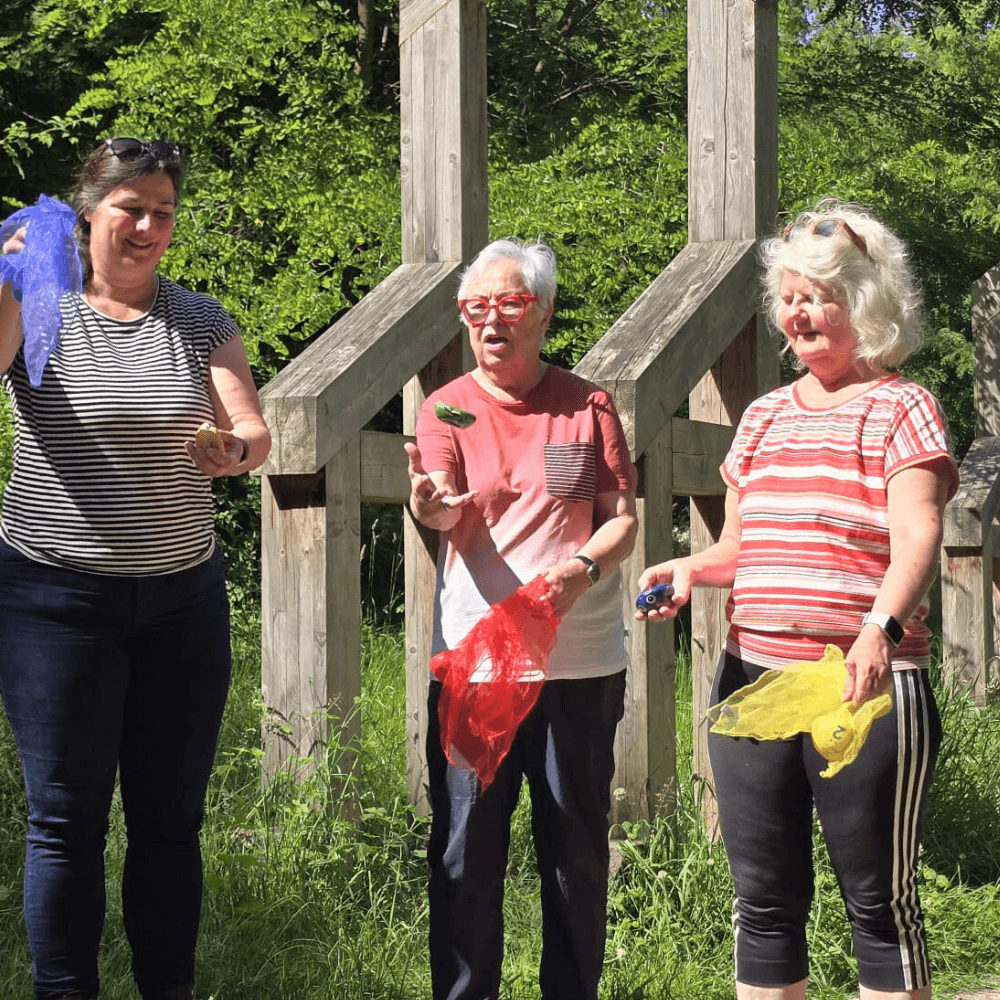 Teilnehmerinnen beim Brainwalking mit Heike Loosen im Vorster Wald in Kaarst vor dem Skulpturenensemble Türhüter von Wilhelm Schiefer